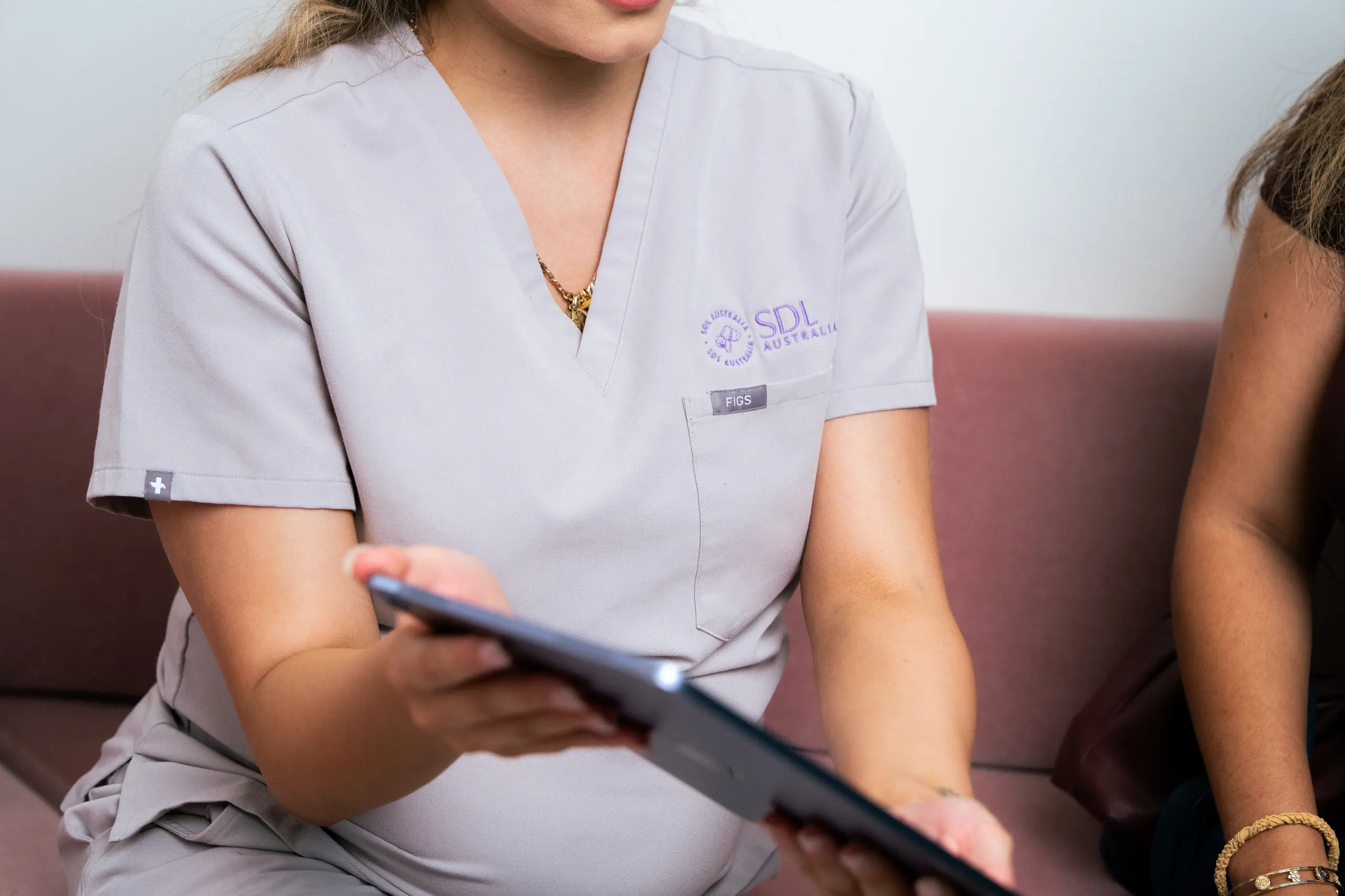 An SDL Australia practitioner in clinic uniform consulting with a client